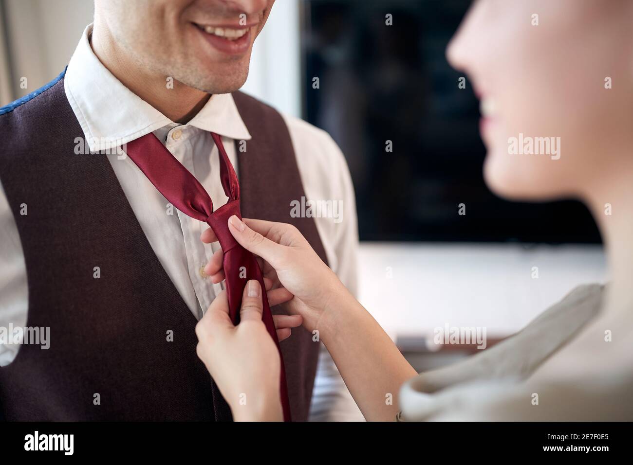 Ein junger Mann auf dem Zimmer bereitet sich auf ein Geschäftstreffen vor und kleidet sich für ein Geschäftstreffen ein. Hotel, Business, Leute Stockfoto