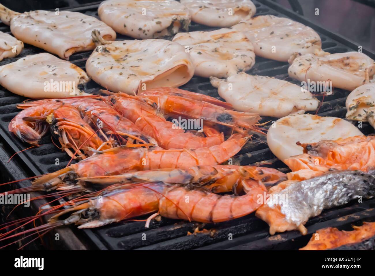 Prozess der Zubereitung von roten Kaisergranat-Garnelen, Tintenfischen,  Lachssteaks auf dem Grill Stockfotografie - Alamy
