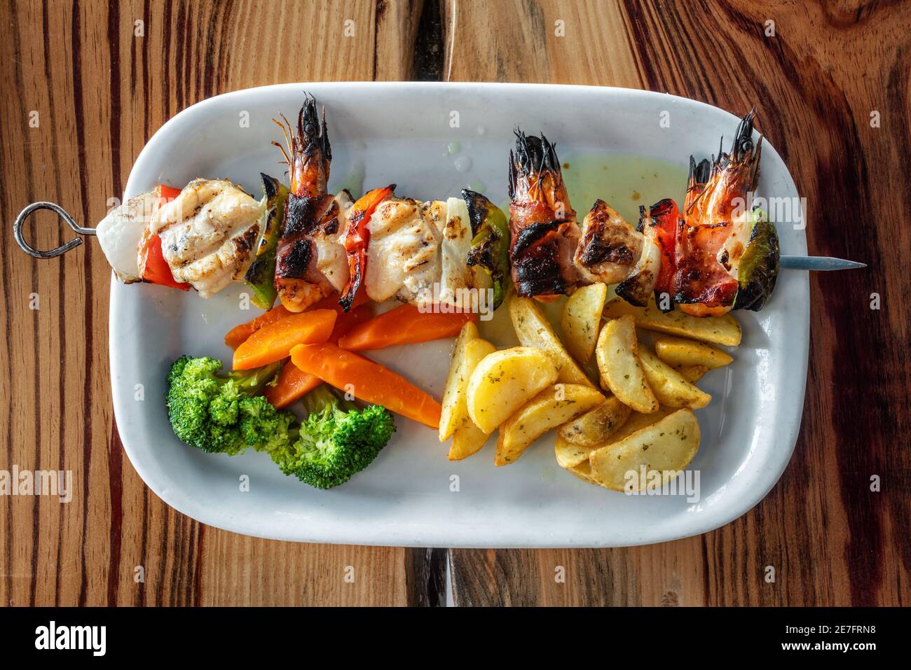 Gegrillter Fisch-Spieß aus Garnelen, Fisch und Paprika mit Chips ...