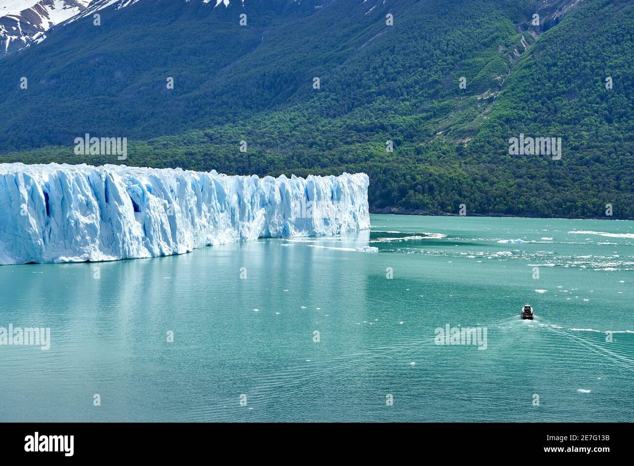 Blaues Eis des Perito Moreno Gletschers im Glaciers Nationalpark in Patagonien, Argentinien mit einem Touristenboot auf dem türkisfarbenen Wasser des Lago Argentino in Th Stockfoto