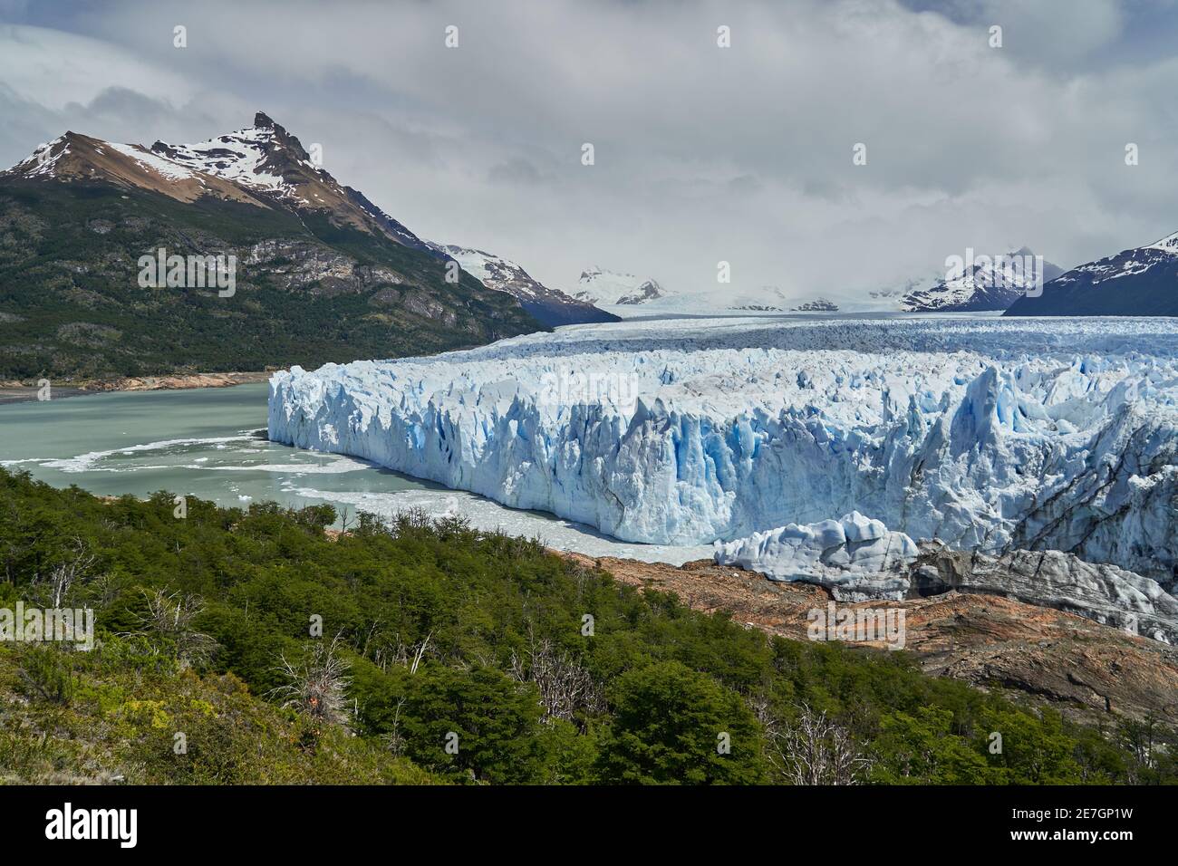 Blaues Eis des Perito Moreno Gletschers im Glaciers Nationalpark in Patagonien, Argentinien mit dem türkisfarbenen Wasser des Lago Argentino im Vordergrund, dunkel Stockfoto