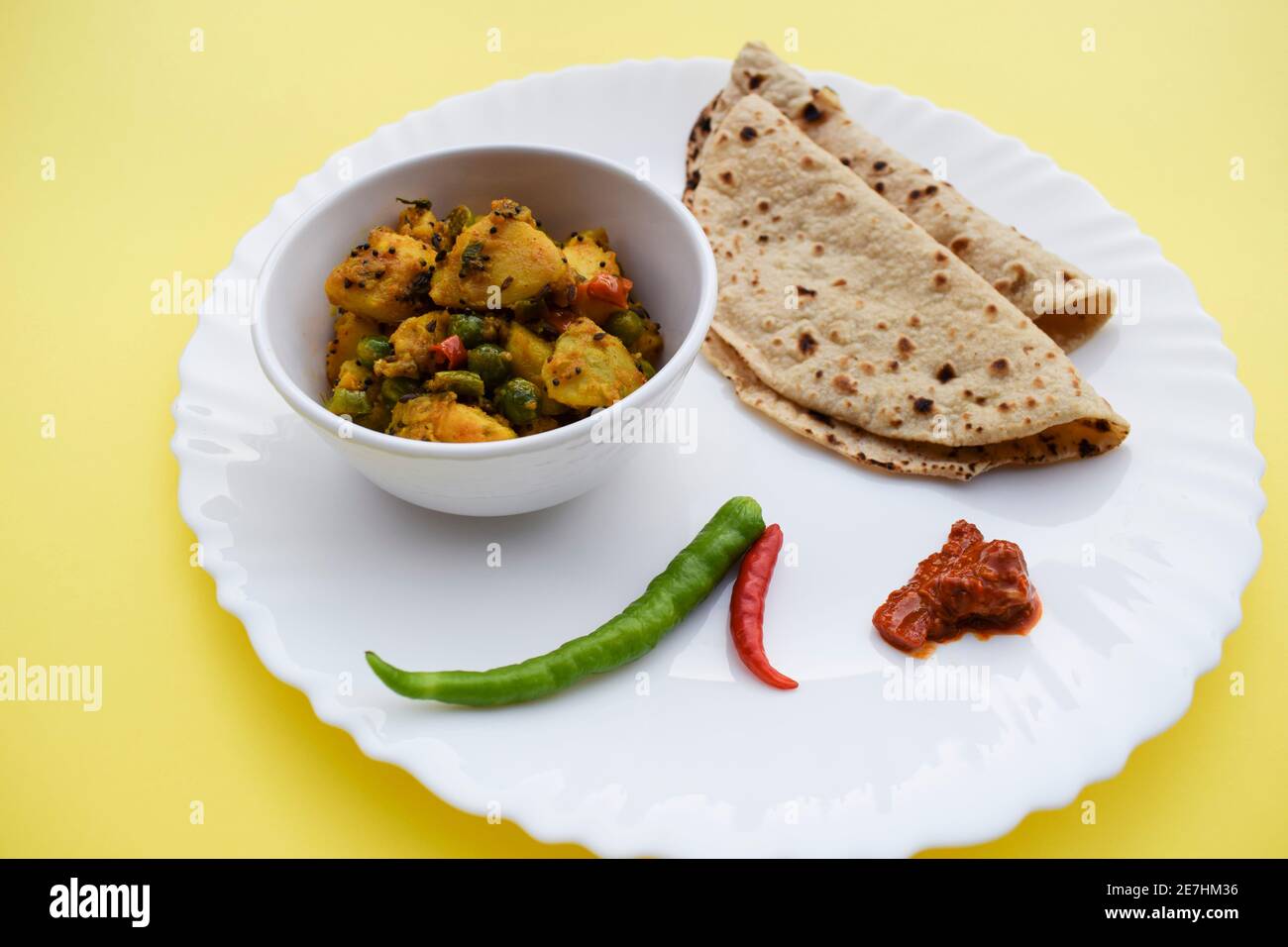 Selektiver Fokus der indischen Beilage Curry Aloo mattar KI sabzi, beliebtes Curry aus Kartoffeln und grünen Erbsen serviert mit Chapatis Stockfoto