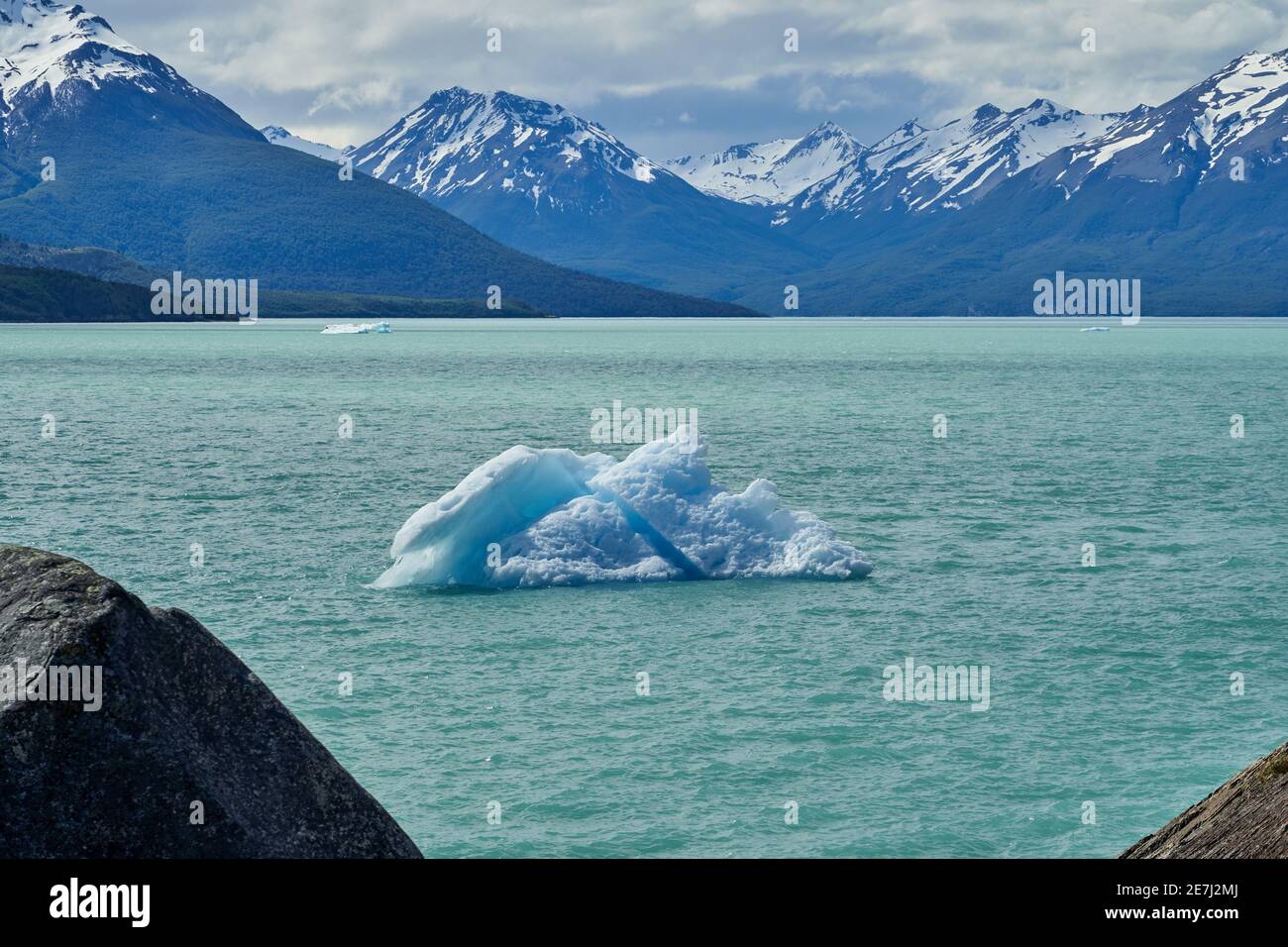 Blaues Eis des Perito Moreno Gletschers im Glaciers Nationalpark in Patagonien, Argentinien mit einem Eisberg auf dem türkisfarbenen Wasser des Lago Argentino in der fo Stockfoto