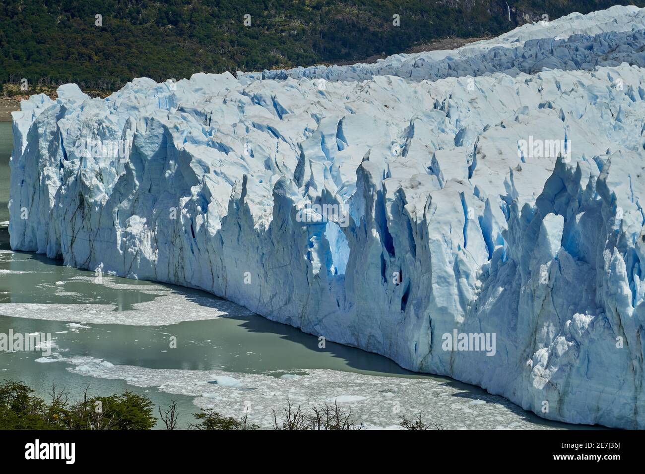 Blaues Eis des Perito Moreno Gletschers im Glaciers Nationalpark in Patagonien, Argentinien mit dem türkisfarbenen Wasser des Lago Argentino im Vordergrund, dunkel Stockfoto