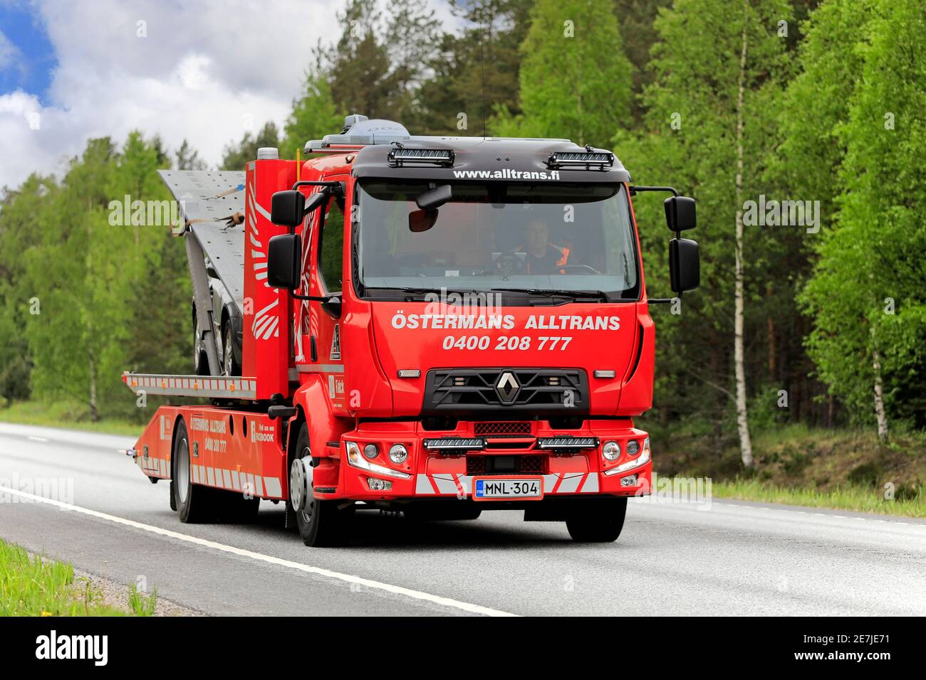 Renault Flachbett Recovery Vehicle von Ostermans ALLTRANS ab Oy trägt beschädigte Auto entlang der Autobahn an bewölktem Tag. Raasepori, Finnland. 24.Mai 2019. Stockfoto