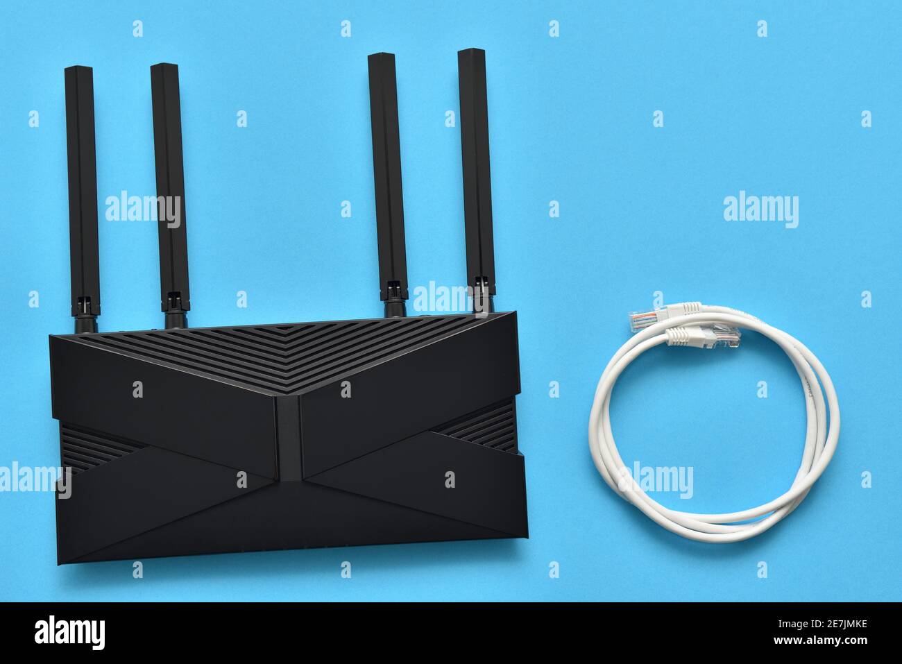 Moderner wlan-Router und ethernet-Kabel für den Anschluss an ein Blauer Hintergrund Stockfoto