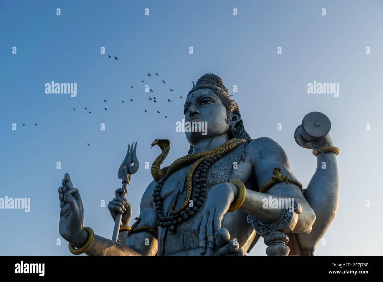 Landschaftsansicht der zweithöchsten Lord Shiva oder Shankara Statue in der Welt mit einem Schwarm für Vögel fliegen. Die Staue liegt an der Küste von Ara Stockfoto