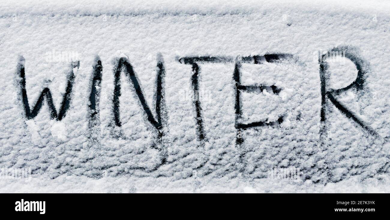 Wort Winter mit Finger im Neuschnee auf Auto geschrieben Angezeigt Stockfoto