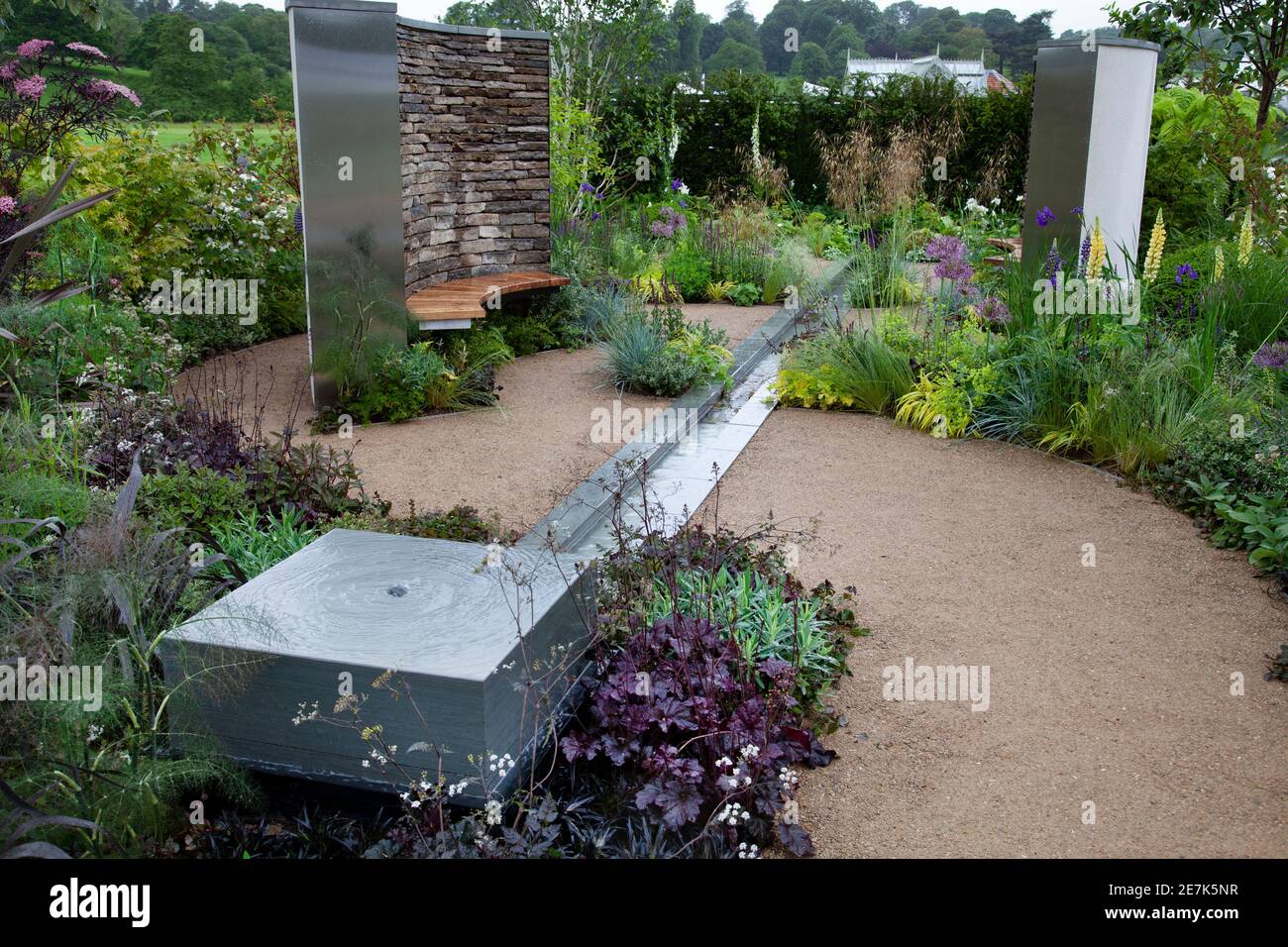 Das Rillwasser verfügt über Sezing Betten von Sambucus nigra 'Black Lace', Lupinen, Allium, heuchera 'Obsidian', in der Cruse Trauerpflege: Eine Zeit für Stockfoto