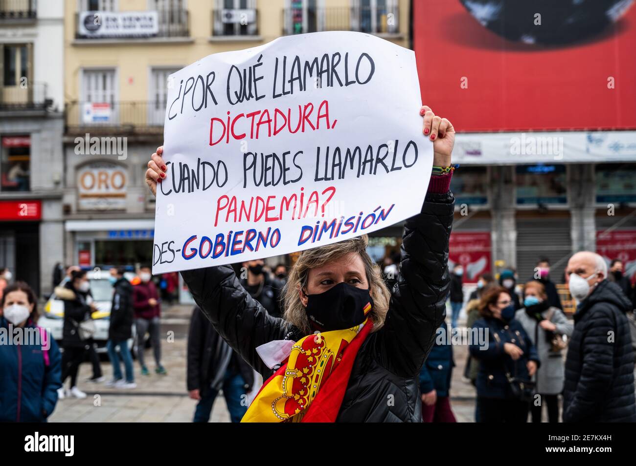 Madrid, Spanien. Januar 2021. Eine Frau, die ein Plakat mit der Aufschrift "Warum Diktatur nennen, wenn man es Pandemie nennen kann" trägt, protestiert während einer Demonstration gegen die Regierung von Pedro Sanchez. Quelle: Marcos del Mazo/Alamy Live News Stockfoto