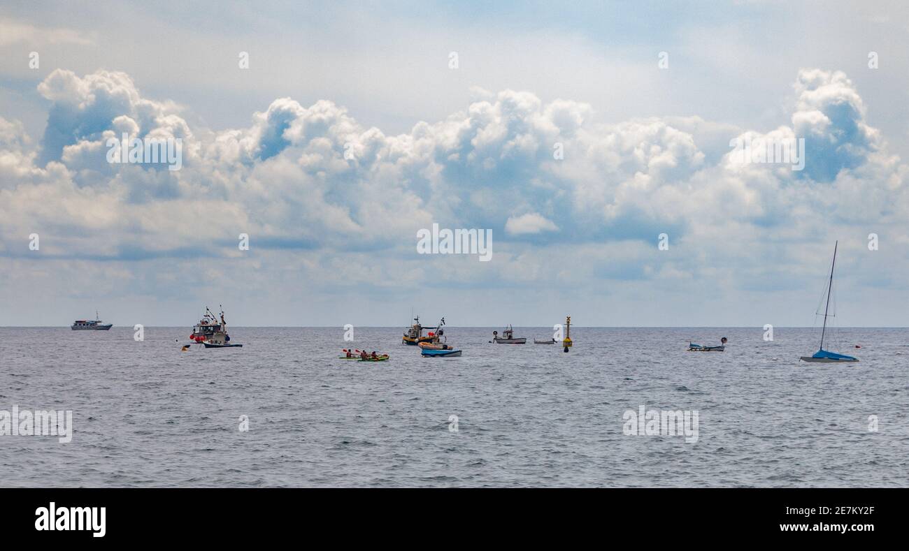 Ein Bild von einer Reihe von Booten, die neben einem bewölkten Himmel ruhen und von Monterosso al Mare aus aufgenommen wurden. Stockfoto