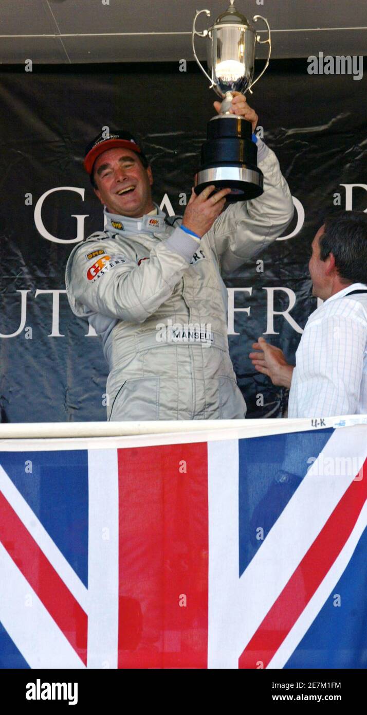 Brite Nigel Mansell hält die Trophäe nach dem Gewinn der Grand Prix Masters-Rennen auf der Rennstrecke Kyalami in der Nähe von Johannesburg 13. November 2005. Mansell, 52, führte die 30-Runden-Rennen von Anfang bis Ende und wehrte die Herausforderung von Brasiliens Emerson Fittipaldi, um weniger als eine halbe Sekunde zu gewinnen. REUTERS Juda Ngwenya Stockfoto