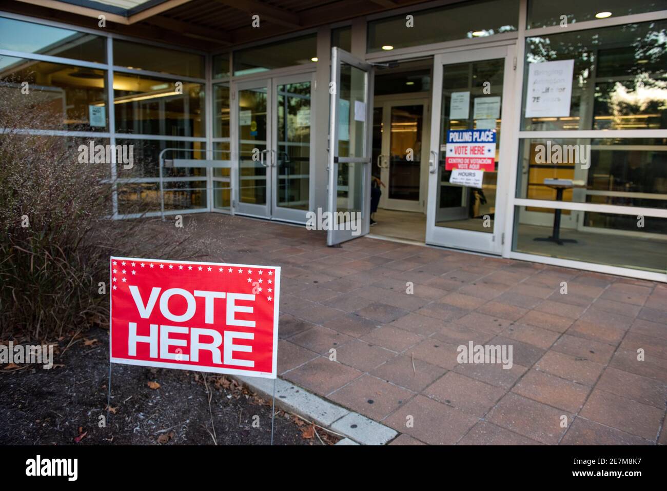 Ein rotes Schild mit der Aufschrift "Vote here" vor einem Wahllokal in Arlington, Virginia. Stockfoto