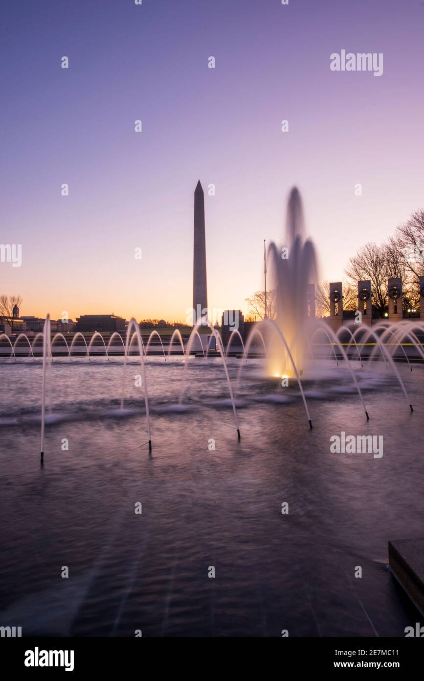 Der Himmel leuchtet lila im Licht der Morgenröte am World war II Memorial in der National Mall in Washington, DC. Stockfoto