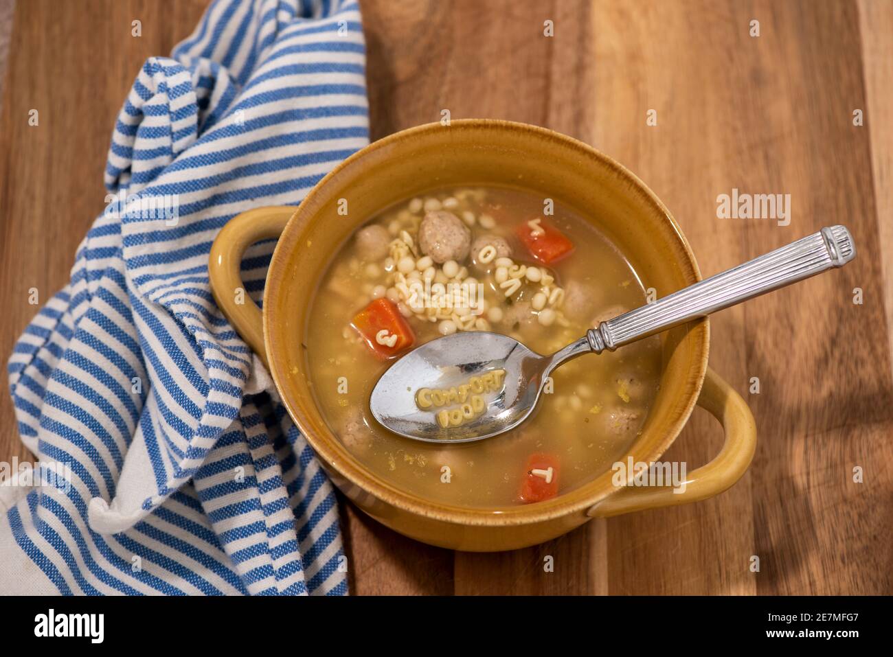 Ein Löffel Hühnchen Nudel Alphabet Suppe buchstabiert "KOMFORT-ESSEN". Stockfoto