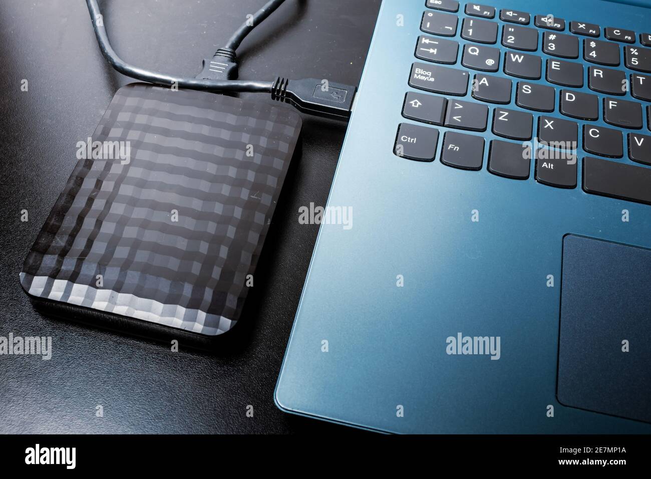 Externe Festplatte mit usb-Kabel an einen Laptop oder Notebook-Computer auf einer schwarzen Oberfläche angeschlossen. Concept-Technologie Stockfoto