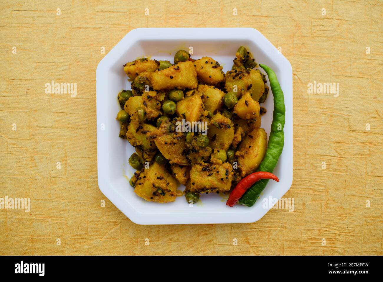 Selektiver Fokus der indischen Beilage Curry Aloo mattar KI Sabzi, beliebtes Curry aus Kartoffeln und grünen Erbsen auf weißem Hintergrund Stockfoto