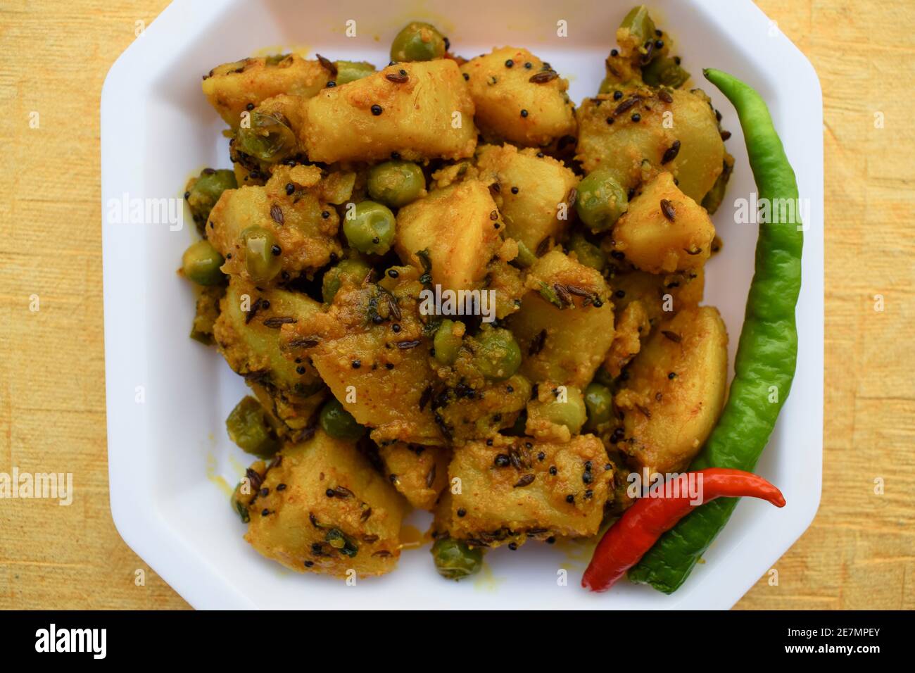 Selektiver Fokus der indischen Beilage Curry Aloo mattar KI Sabzi, beliebtes Curry aus Kartoffeln und grünen Erbsen auf weißem Hintergrund Stockfoto