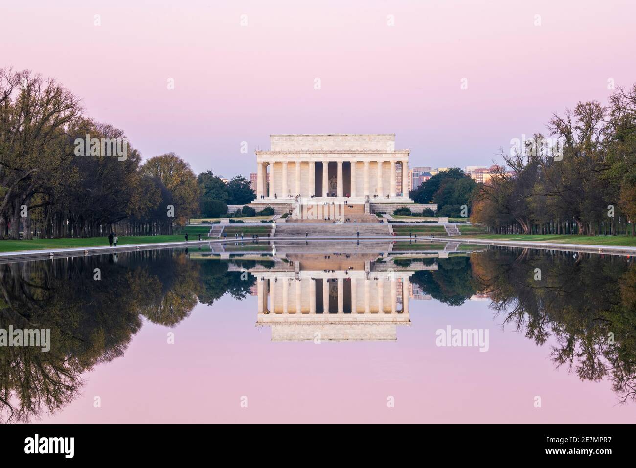 Ein rosafarbener Himmel und das ikonische Lincoln Memorial aus elfenbeinfarbenem Marmor spiegeln sich an einem frischen Herbstmorgen in Washington, DC, im reflektierenden Pool. Befindet sich im Stockfoto