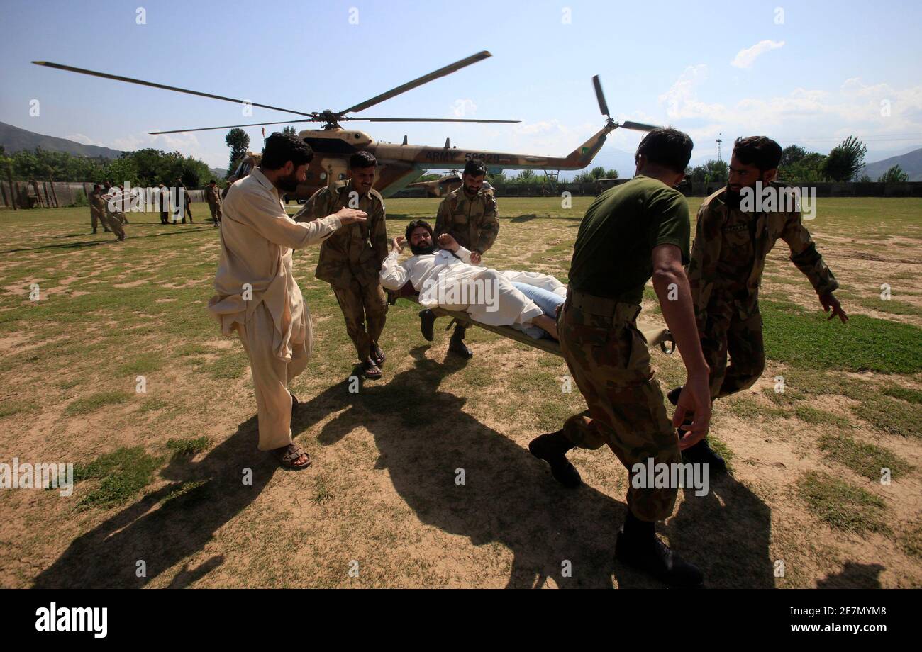 Armeesoldaten helfen, einen Mann zu evakuieren, nachdem er per Hubschrauber zu einer Militärbasis in Khuazakhela im Swat-Bezirk in Pakistans nordwestlicher Provinz Khyber-Pakhtunkhwa kam 1. August 2010. Überschwemmungen, die durch eine Woche starken Regens verursacht wurden, haben mehr als 1,000 Menschen im Nordwesten Pakistans getötet, und Retter kämpften am Sonntag um die Verteilung von Hilfsmaßnahmen an Zehntausende Gefangene Menschen. REUTERS/Faisal Mahmood (PAKISTAN - Tags: KATASTROPHENUMWELT) Stockfoto