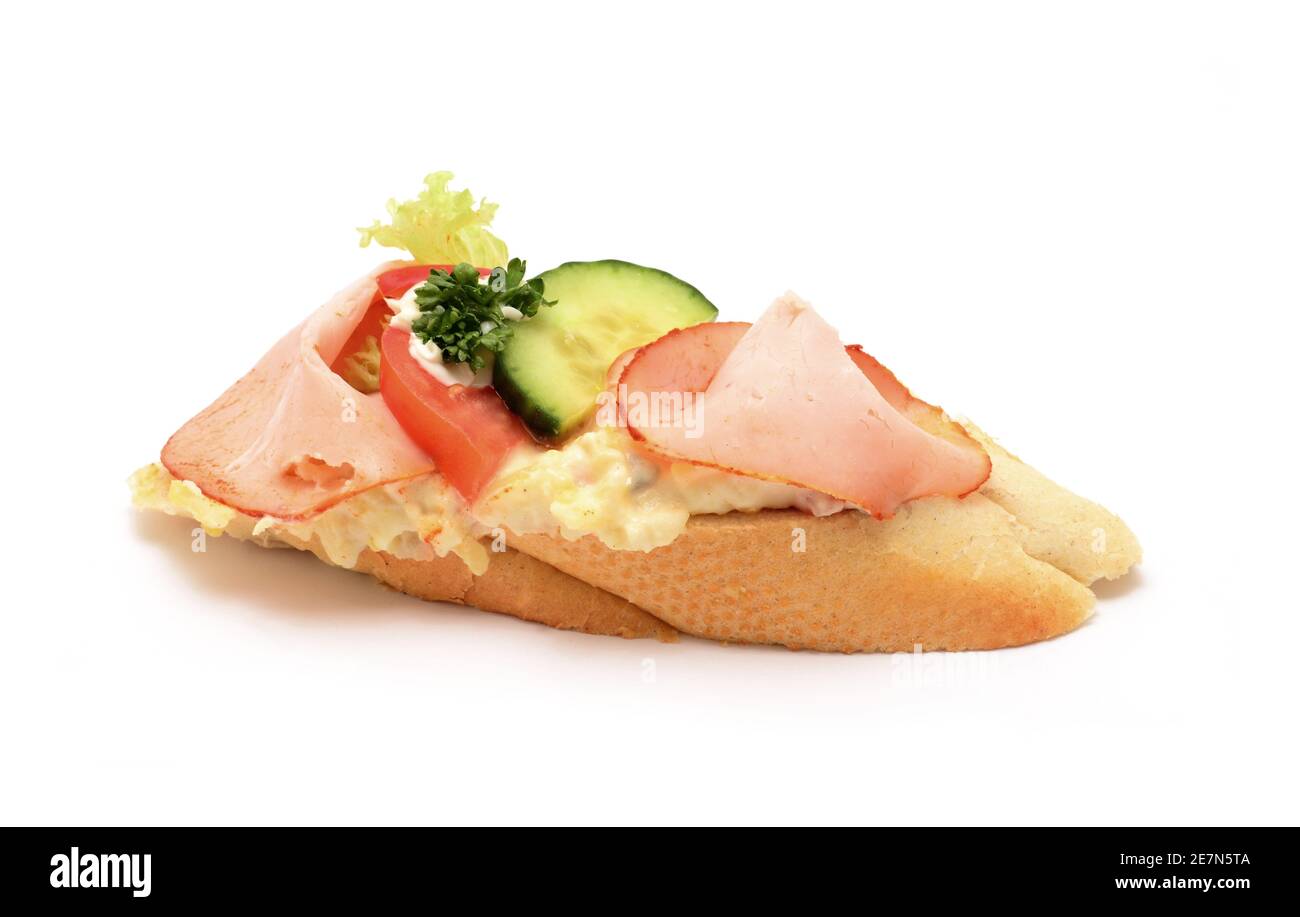 Traditionelle tschechische Snack namens chlebicek. Schinkenscheiben, Gurken und Tomate mit Mayonnaise dekorativ auf kleines weiches Weißbrot gelegt. Stockfoto