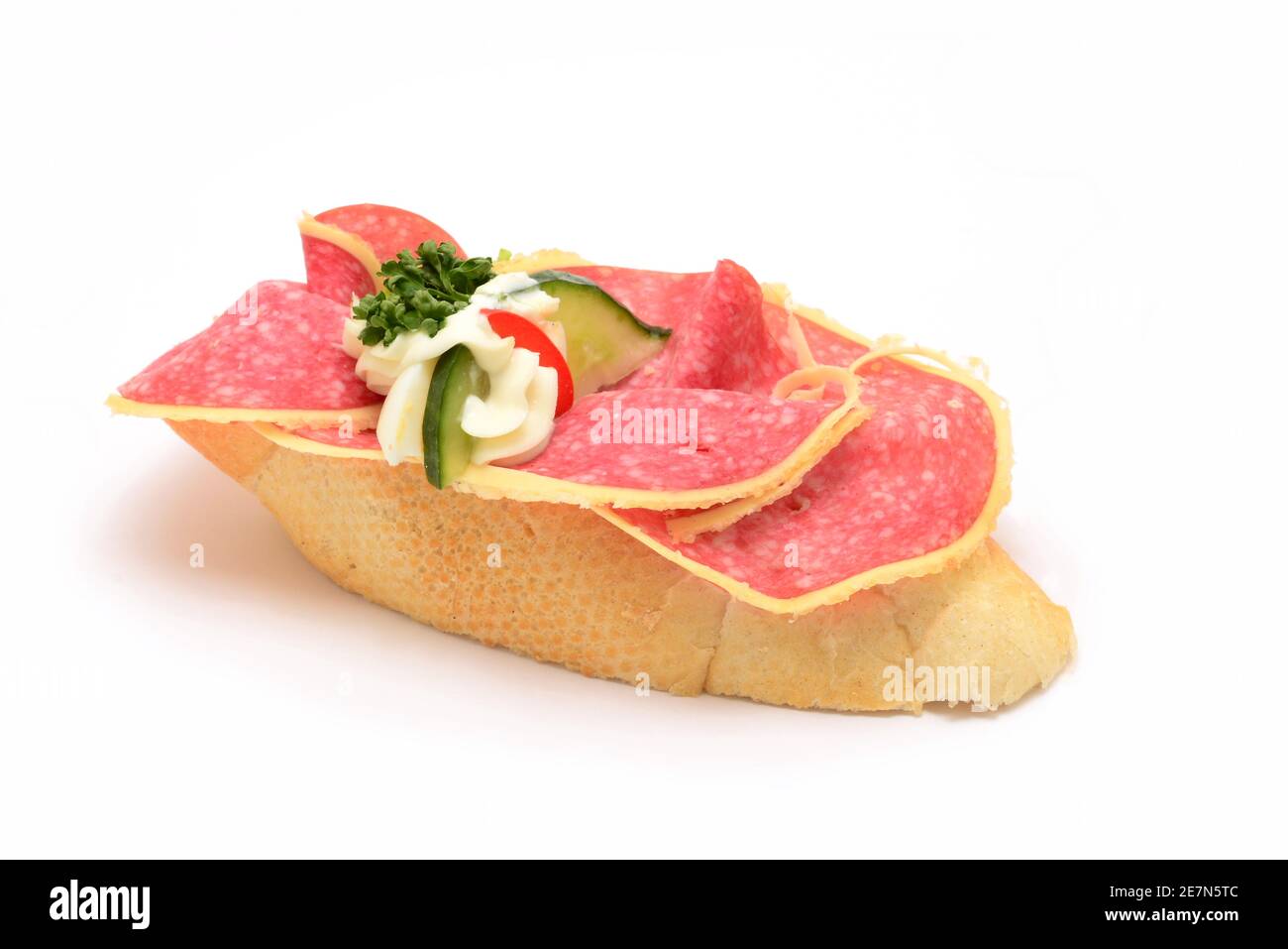 Traditionelle tschechische Snack namens chlebicek. Salami- und Gurkenscheiben mit Mayonnaise dekorativ auf kleines, weiches Weißbrot gelegt. Stockfoto