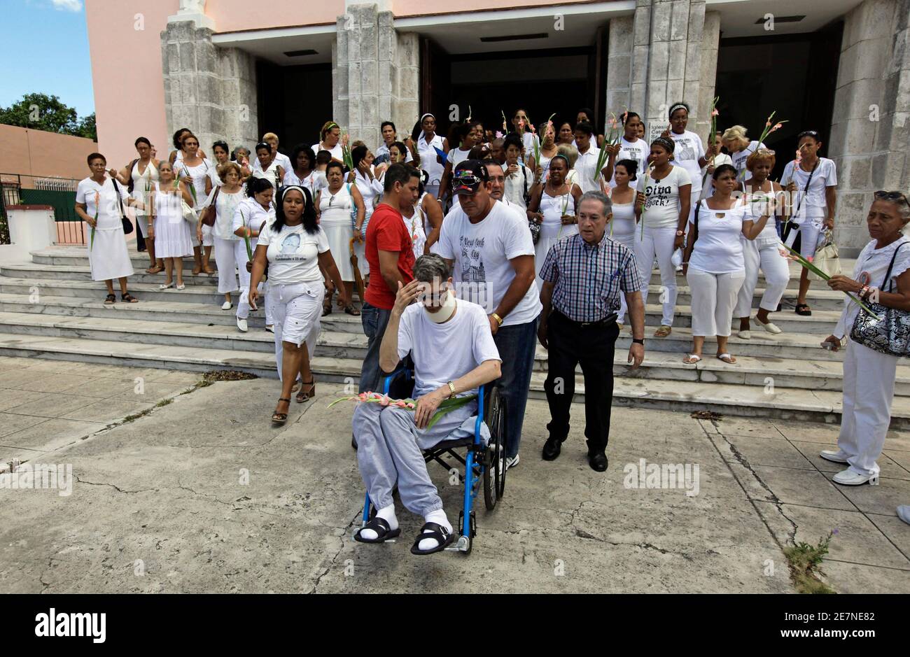 Freigegebene Häftling Ariel Sigler Amaya sitzt in einem Rollstuhl in der Santa Rita Church wie er den wöchentlichen Protest der Damen in weiß, eine Gruppe von inhaftierten Familienangehörigen in Havanna 20. Juni 2010 verbindet. Die kubanische Regierung veröffentlichte Sigler, die in gesundheitlichen, auf Bewährung und zog sechs weitere in Gefängnissen näher zu ihren Häusern in eine humanitäre Geste versprach, katholische Führer Kubas. Kubanische Führer betrachten Dissidenten zu Söldner arbeiten mit den Vereinigten Staaten, die kommunistisch geführte Regierung zu stürzen. Sigler war ein unabhängiger Journalist vor seiner Verhaftung. REUTERS/Desmond Boylan (Kuba - T Stockfoto