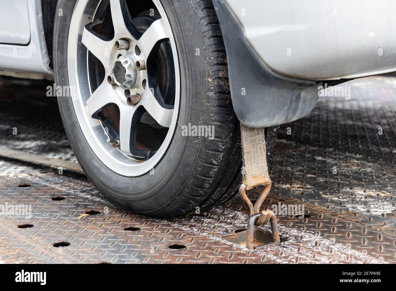 Nahaufnahme des Autorads mit Sicherheitsgurt auf dem Flachbett Abschleppwagen Stockfoto