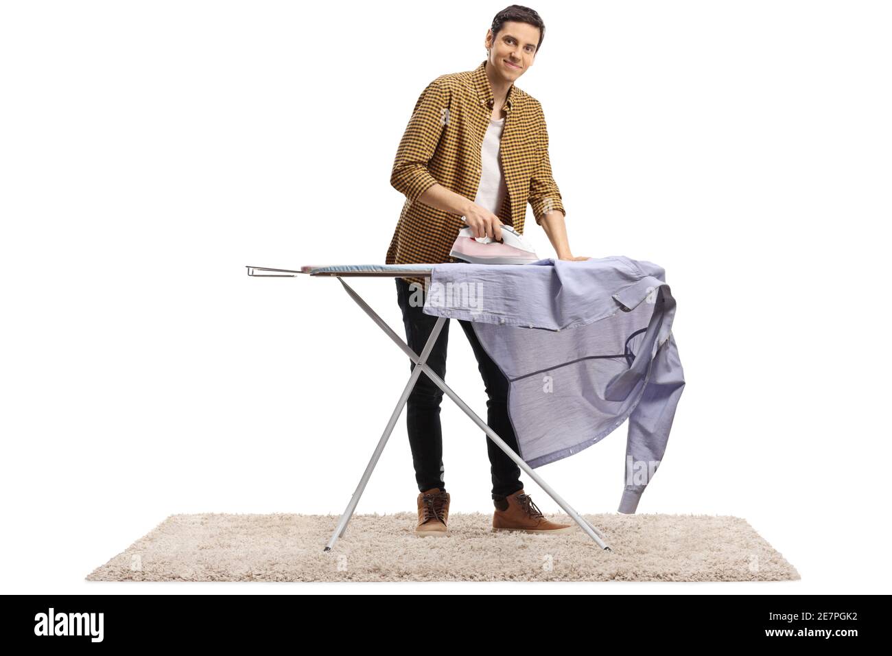 Porträt eines jungen Mannes, der ein Hemd bügelt Und lächelnd auf die Kamera isoliert auf weißem Hintergrund Stockfoto