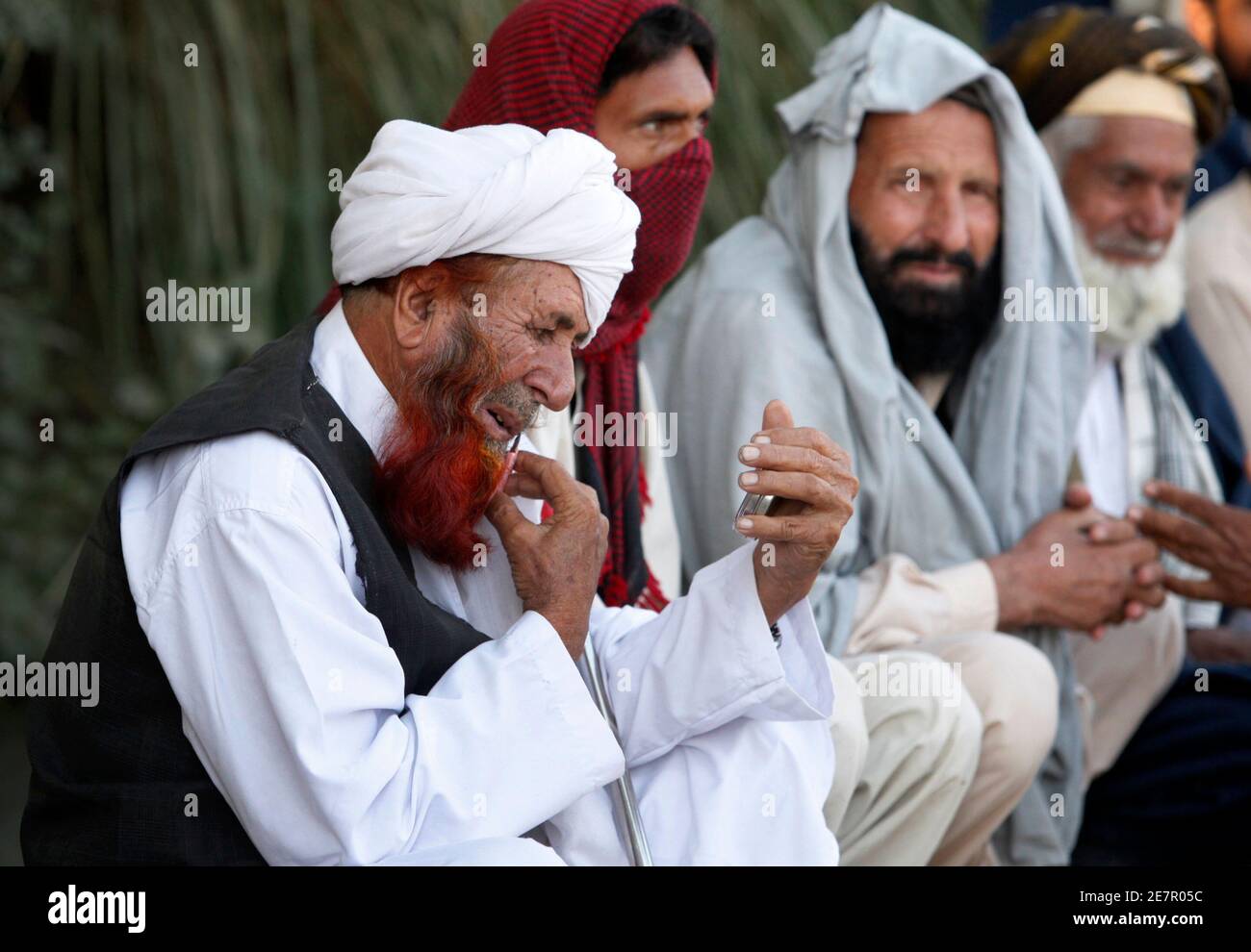 Ein Mann, der eine militärische Offensive gegen Taliban-Kämpfer in Süd-Waziristan floh, Bräutigam selbst während der Wartezeit mit anderen Hilfsgütern für die Binnenvertriebenen (IDPs) um einen Verteilungspunkt in Dera Ismail Khan, befindet sich in Pakistans unruhigen North West Frontier Province 25. Oktober 2009 abholen. Rund 140.000 Mitarbeiter haben vor den Kämpfen geflohen in Süd-Waziristan, laut den Vereinten Nationen  REUTERS/Faisal Mahmood (PAKISTAN-Konflikt-Gesellschaft) Stockfoto