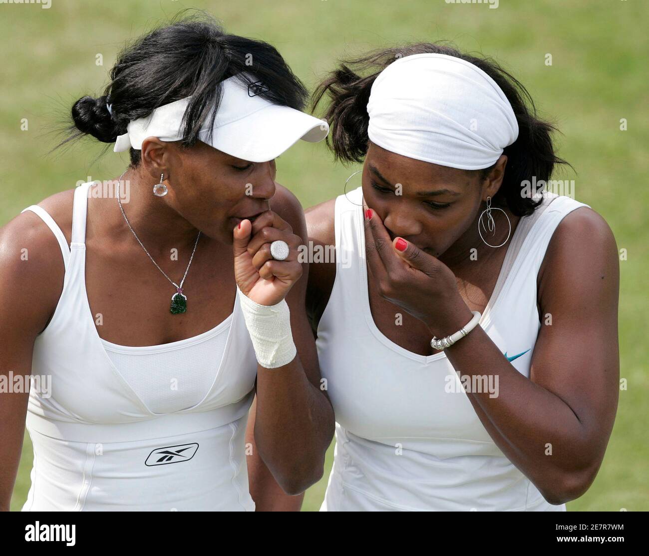 Serena (R) und Venus Williams aus den USA flüstern sich bei ihrem  Doppelspiel gegen die Briten Claire Curran und Anne Keothavong am 28. Juni  2007 bei den Wimbledon-Tennismeisterschaften in London zu. REUTERS/David