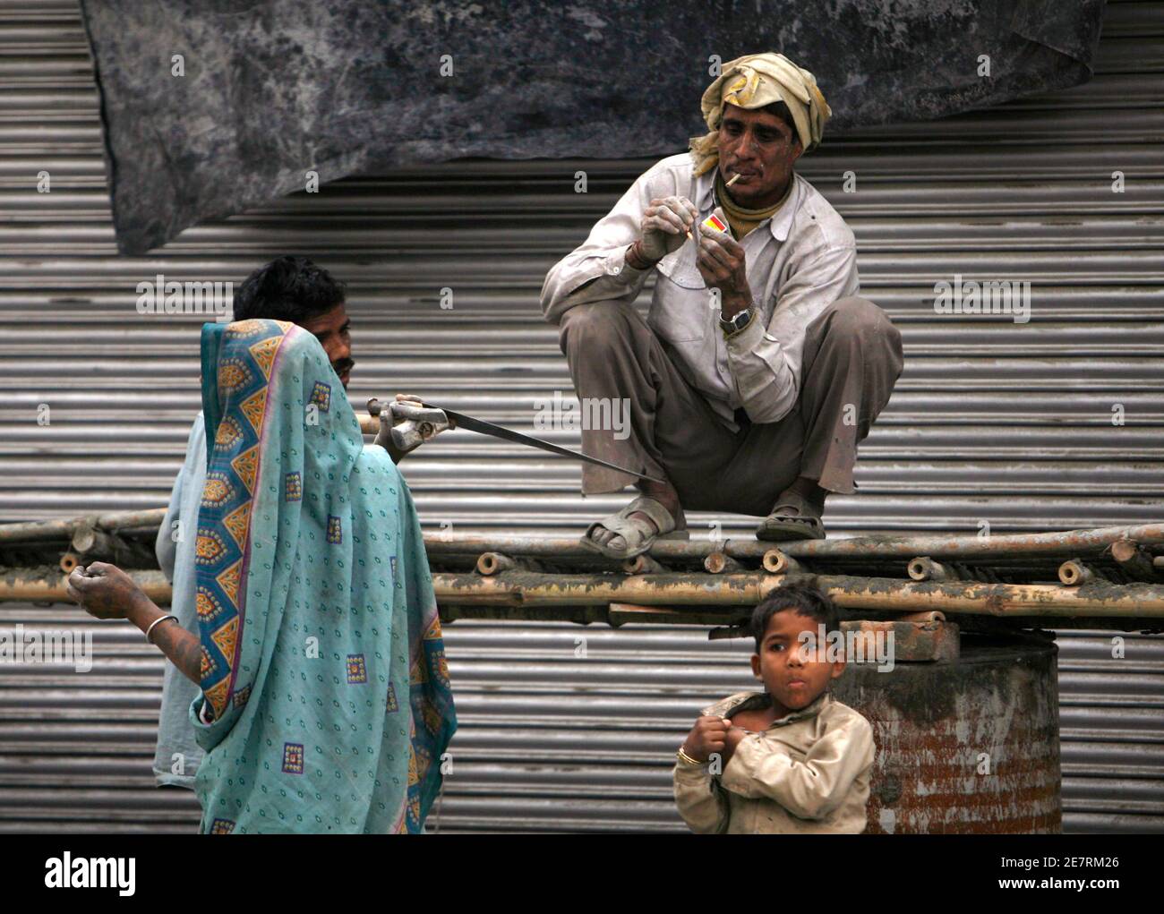 Ein Arbeiter raucht auf einer Baustelle in Neu-Delhi 26. Februar 2007. REUTERS/Desmond Boylan (Indien) Stockfoto