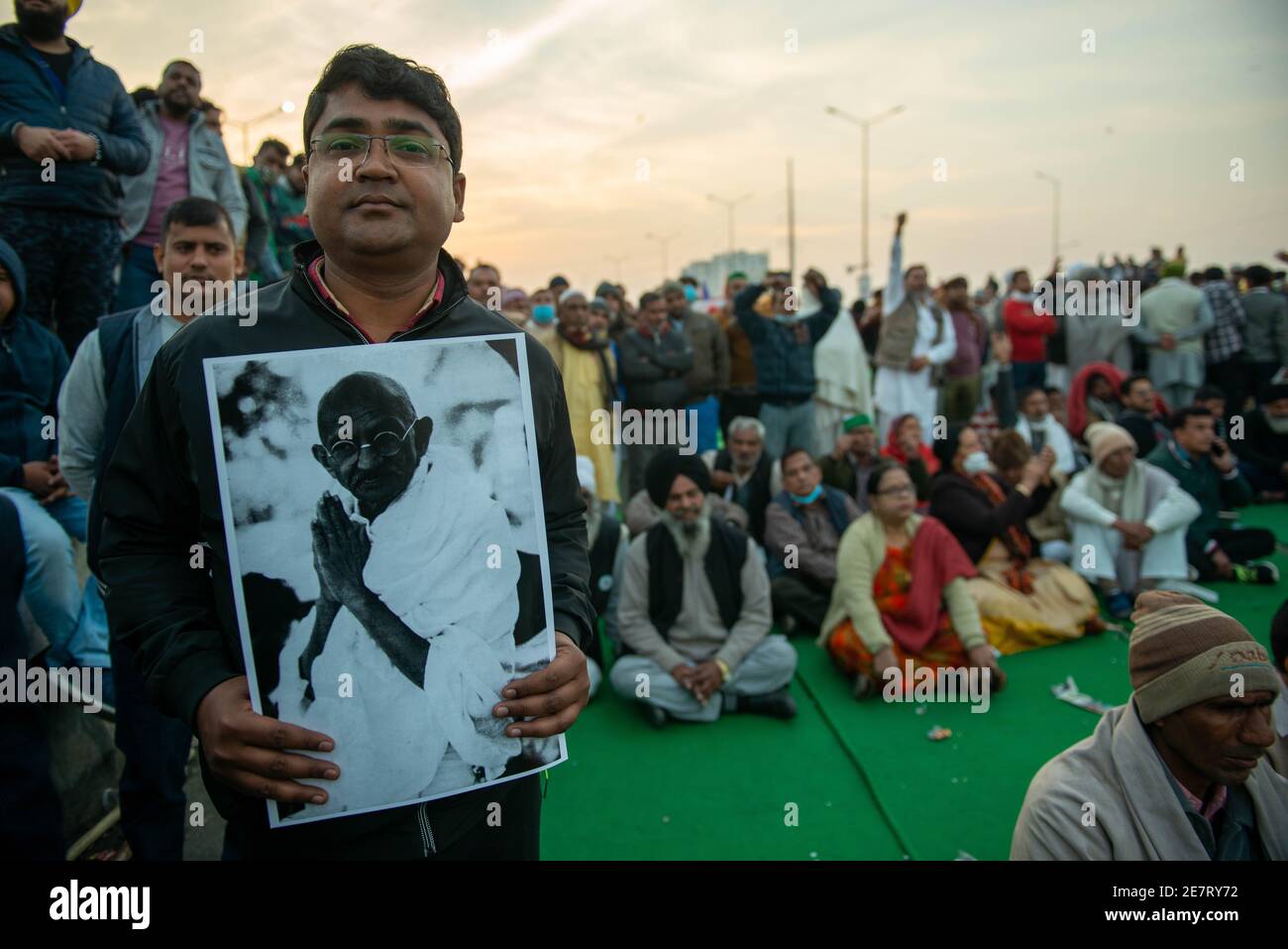 Ein Protestant, der während der Demonstration ein Porträt von Mahatma Gandhi hält.der Gewerkschaftsführer von Bhartiya kisan, Rakesh Tikait und die Bauern protestieren gegen die neuen Agrargesetze der Regierung.Farmer-Führer beobachteten ein eintägiges Fasten am Todestag von Mahatma Gandhi. Stockfoto