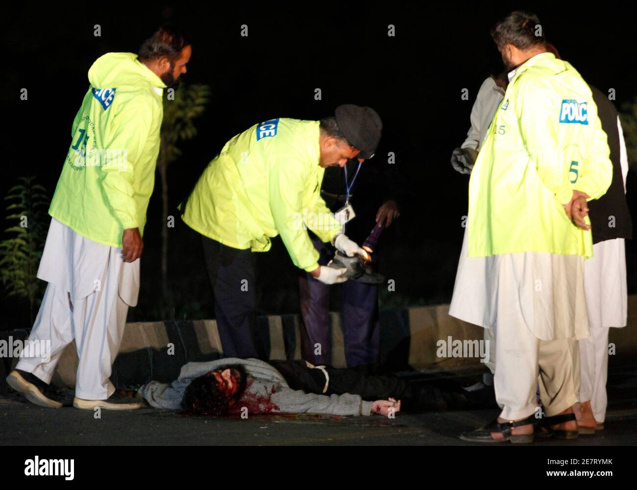 Polizeibeamte inspizieren in Islamabad am 8. November 2009 einen Schuh in der Nähe des Leibes eines Toten. Die Polizei habe am Sonntagabend einen mutmaßlichen Selbstmordattentäter nach einem gescheiterten Anschlag in Islamabad erschossen, berichteten lokale Medien. REUTERS/FAISAL MAHMOOD (PAKISTAN KONFLIKT POLITIK KRIMINALITÄT GESETZ) Stockfoto