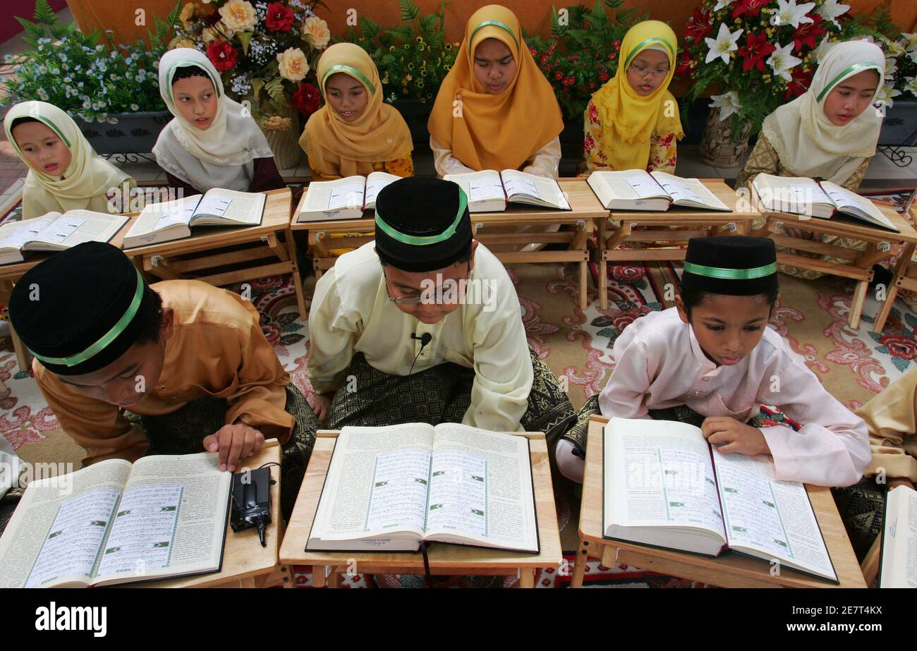 Junge malaysische Muslime rezitieren des Korans während 'Tadarus al-Koran", eine Zeremonie markiert das Ende einer einmonatigen Koran besondere Erwägung, in Putrajaya außerhalb Kuala Lumpur 19. Oktober 2006. Muslime auf der ganzen Welt feiern Lailatul Qadar, "die Nacht der macht Prädestination", die im Koran als "eine Nacht besser als tausend Monate" beschrieben. Anhänger glauben, dass Lailatul Qadar tritt in die letzten 10 Nächte des Fastenmonats Ramadan, die in Malaysia entweder am 13. Oktober begann oder 14, je nach der Sichtung des kommenden neuen Mondes des Syawal.  REUTERS/Bazuki Muhammad (MALAYSIA) Stockfoto