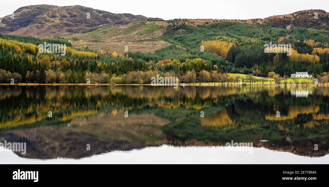 Gespiegelte Herbstreflexionen über Loch Chon in den Trossachs, Schottland, Großbritannien Stockfoto