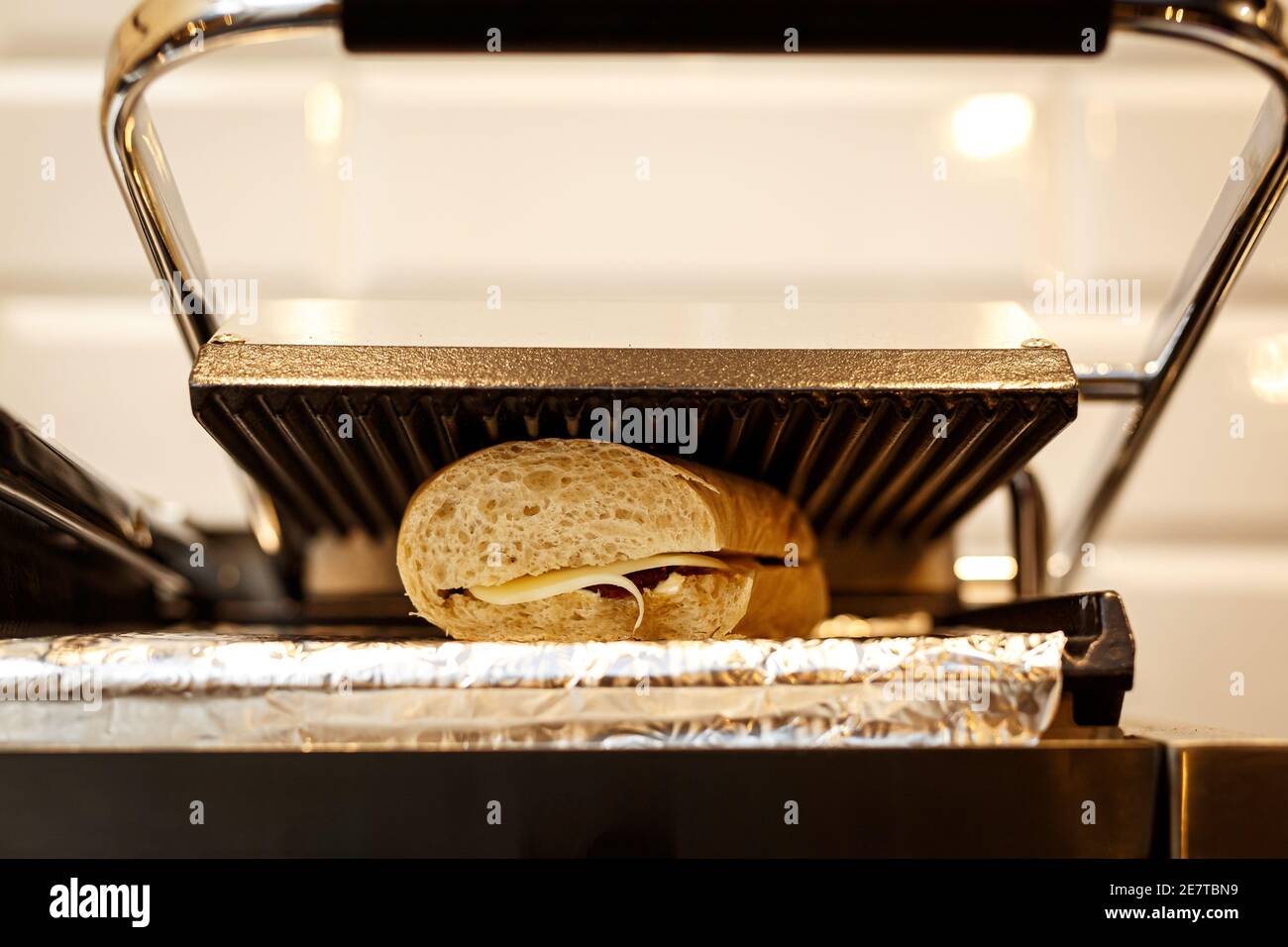 Sandwich-Toaster mit Toast und Zutaten. Stockfoto