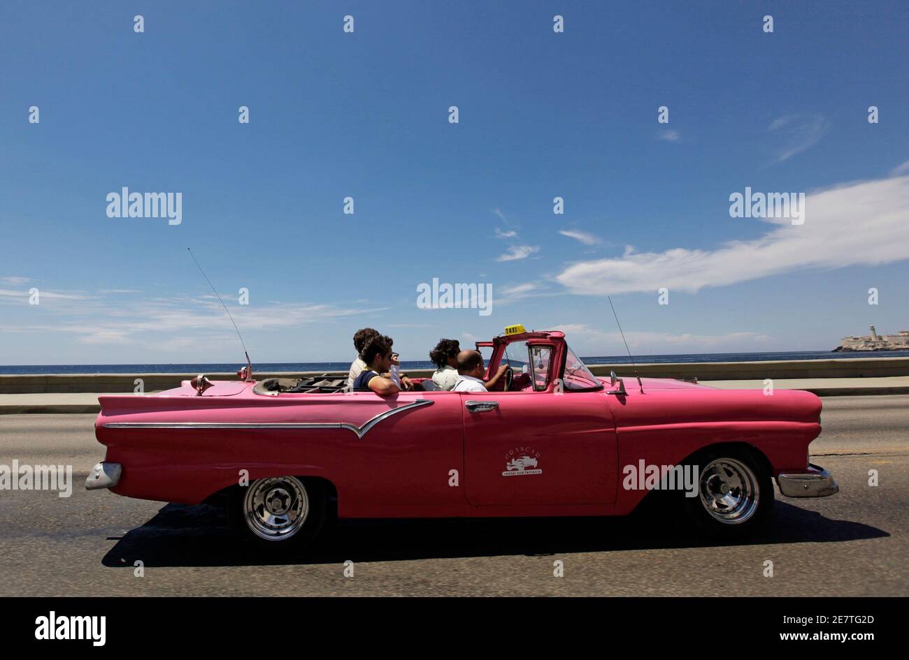Touristen nehmen Sie eine Fahrt in einem rosa 1957 Ford Cabrio Auto entlang der Strandpromenade von Havanna "El Malecon" 17. Juni 2010. REUTERS/Desmond Boylan (Kuba - Tags: Reisen TRANSPORT) Stockfoto