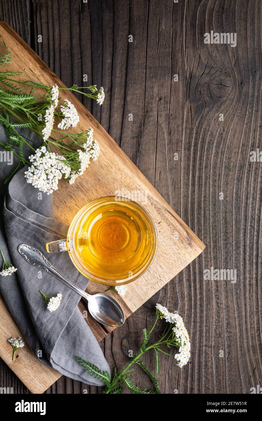 Heilkräuter Tee aus Schafgarbe, Heilmittel zur Wundheilung auf rustikalem Holzhintergrund mit Kopierraum Stockfoto