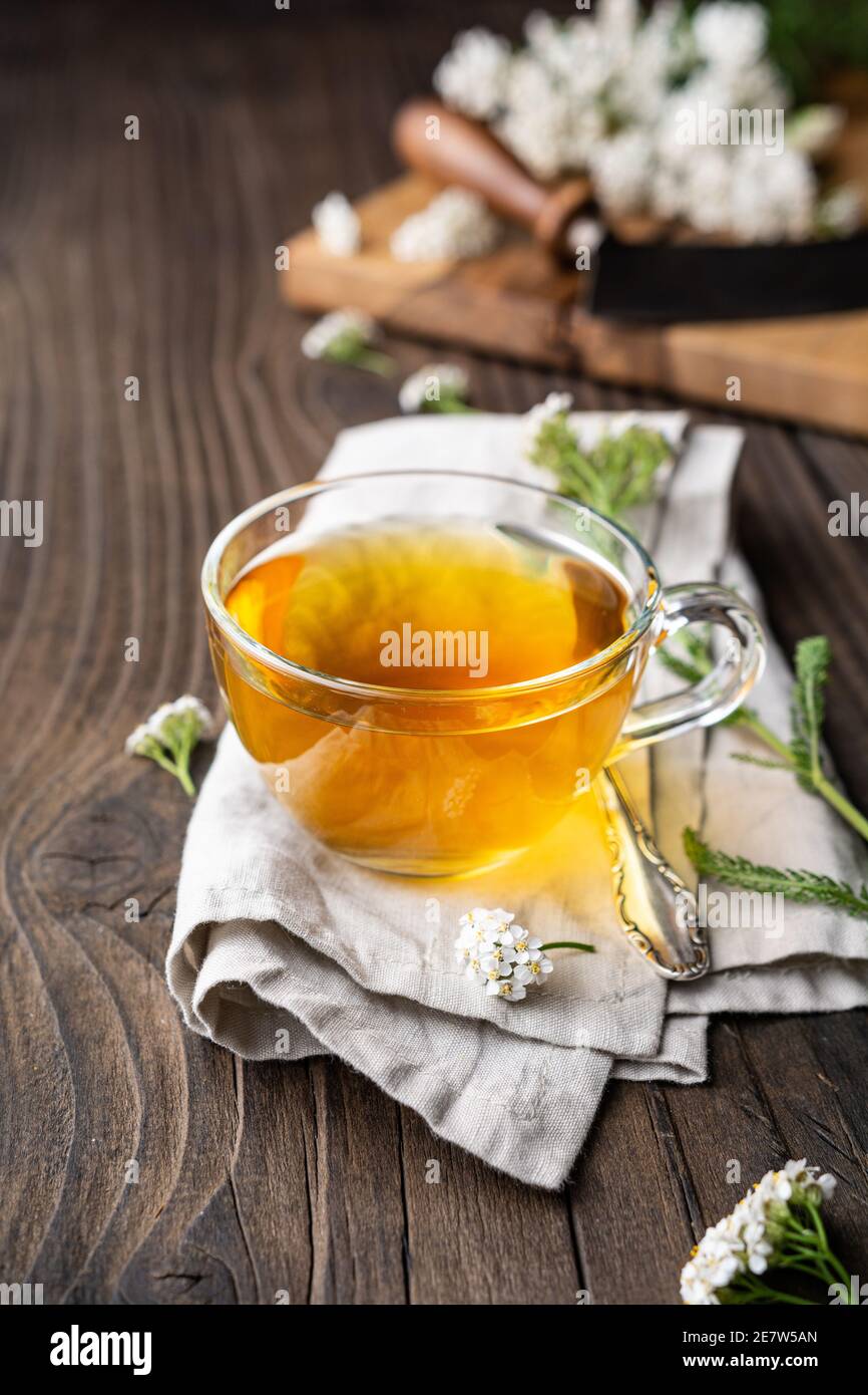 Heilkräuter Tee aus Schafgarbe, Heilmittel zur Wundheilung auf rustikalem Holzhintergrund Stockfoto