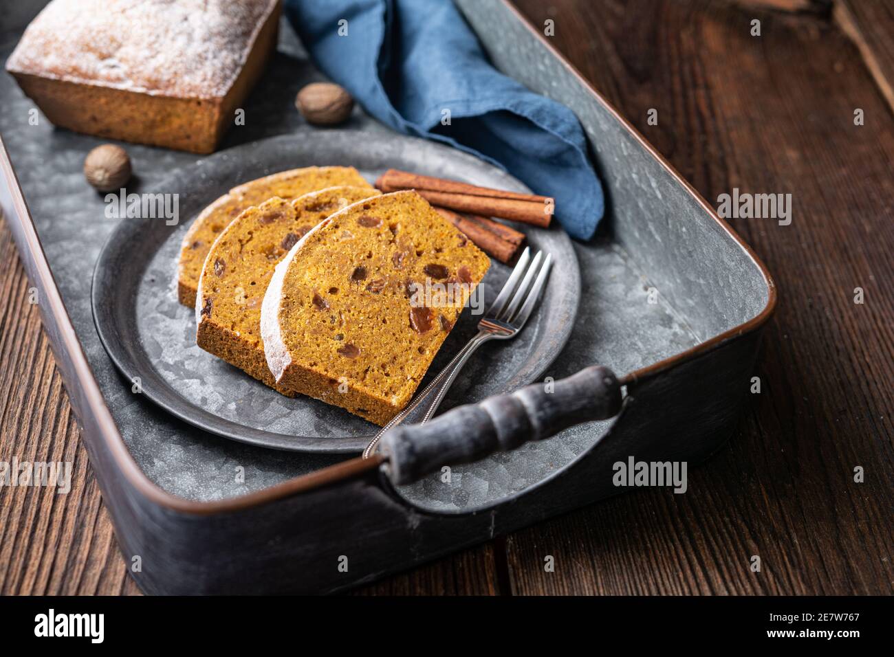 Süßes Vollkorn-Kürbisbrot Scheiben mit Rosinen, bestreut mit Puderzucker auf rustikalem Holzhintergrund Stockfoto