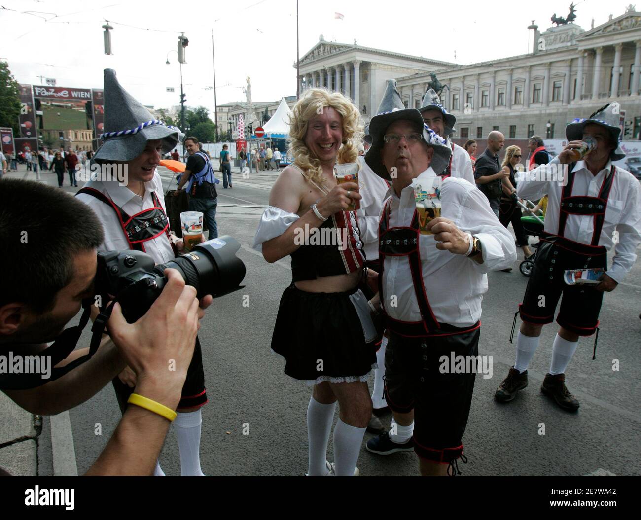 Fußballfans aus England, in Lederhosen- und Dirndl-Kostümen gekleidet, posieren für Fotografen in der offiziellen Euro 2008 Fanzone vor dem Wiener Burgtheater am 7. Juni 2008. REUTERS/Herwig Prammer (ÖSTERREICH) Stockfoto