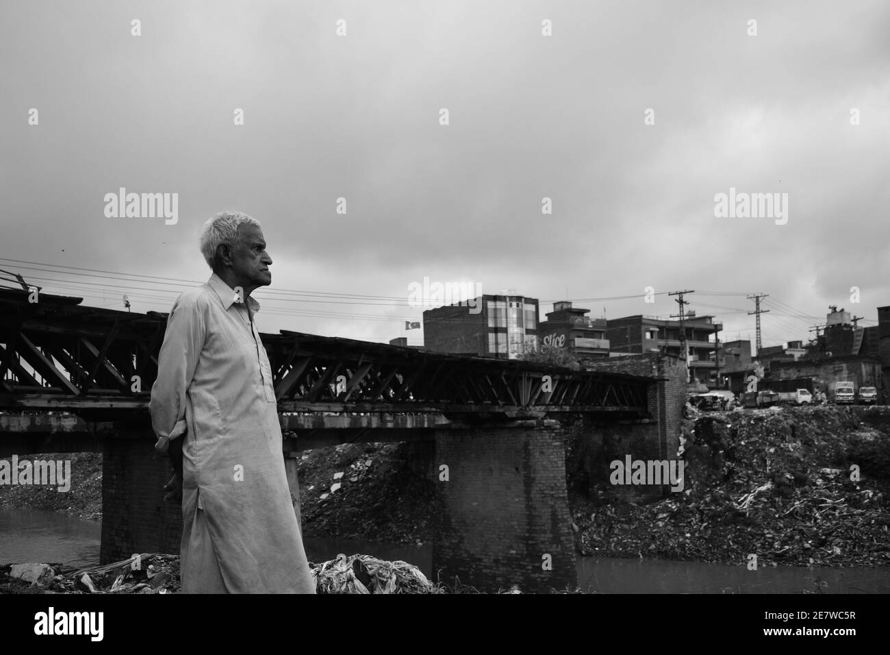 Ein alter Mann, der in der Nähe einer alten britischen Ära vor der Unabhängigkeit steht Eisenbahnbrücke in Androon Rawalpindi Stockfoto