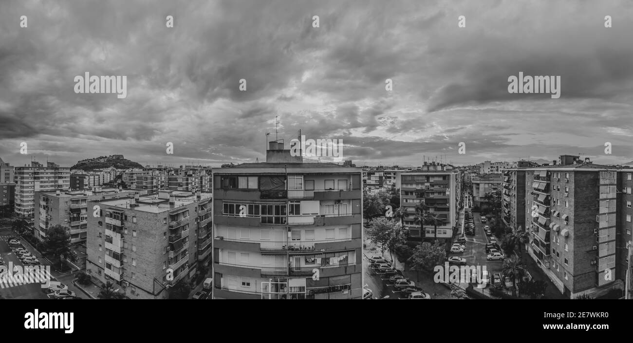 Graustufen Aufnahme von hohen Gebäuden gegen einen bewölkten Himmel Stockfoto