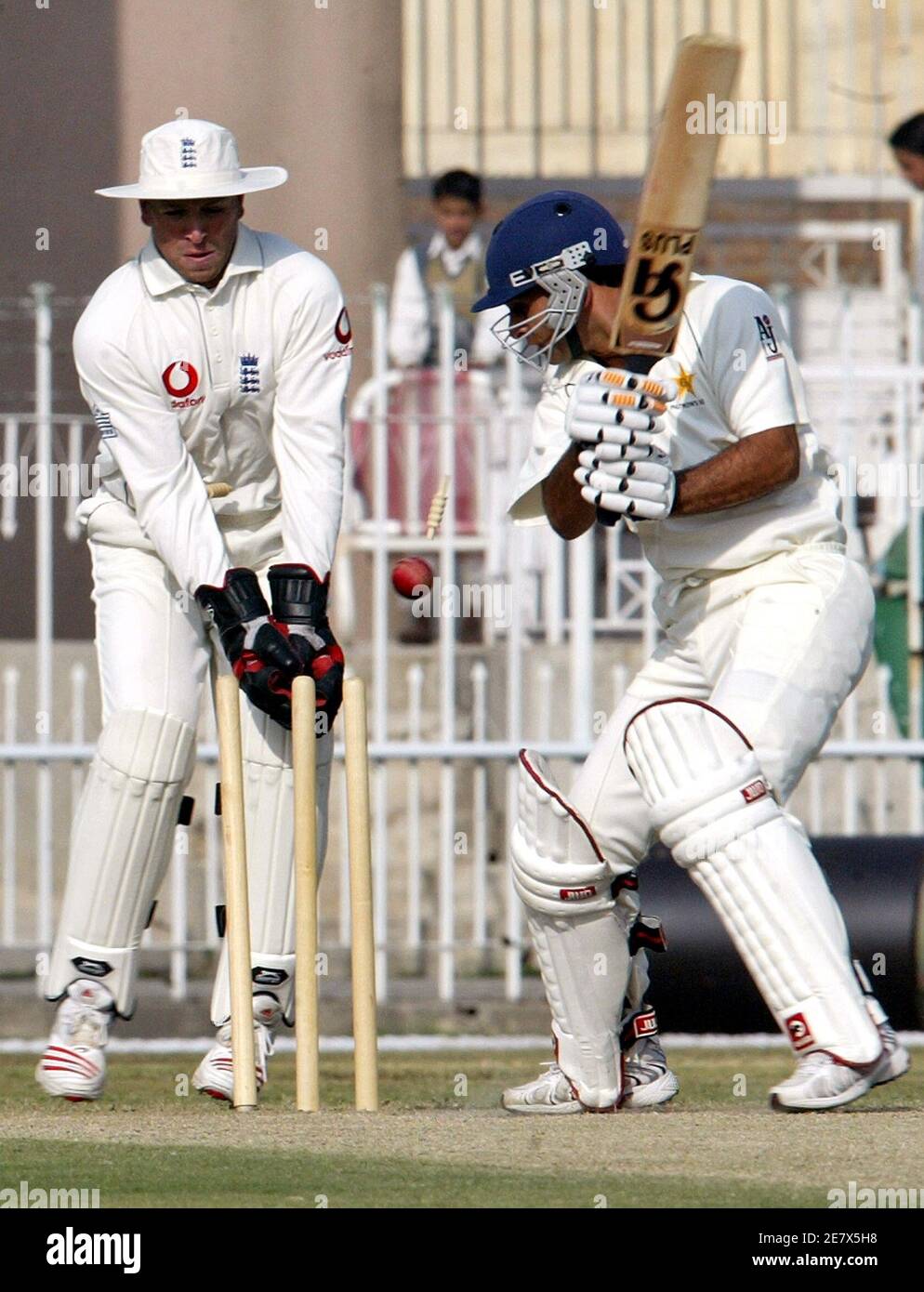 Pakistan Cricket Board (PCB) Patron XI Schlagmann Shahzad Malik (R) ist von Englands Ashley Giles (nicht im Bild) als England Wicketkeeper Matthew Prior am dritten und letzten Tag von ihrem drei-Tage-Spiel in Rawalpindi 2. November 2005 Uhren rollte. REUTERS/Faisal Mahmood Stockfoto