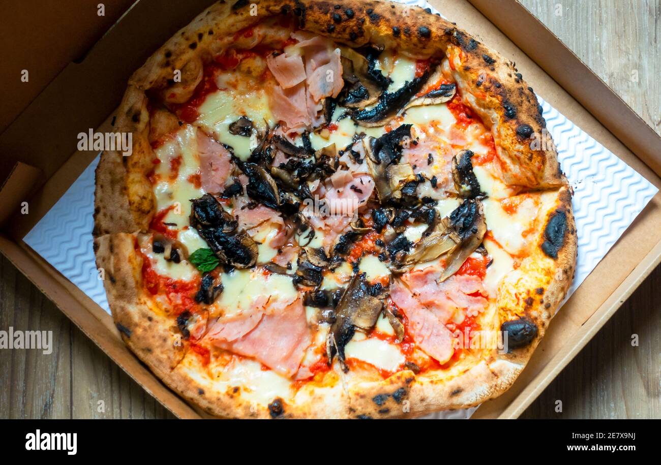 Pizza mit Schinken und Pilzen in einer Schachtel zum Mitnehmen Stockfoto