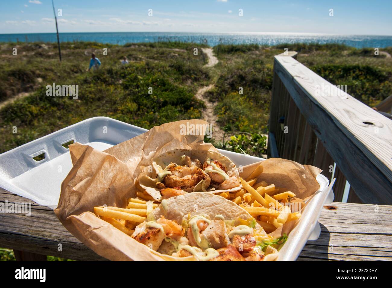 Frischer Fisch und Garnelentacos mit pommes Frites mit Blick auf den Atlantik. Stockfoto