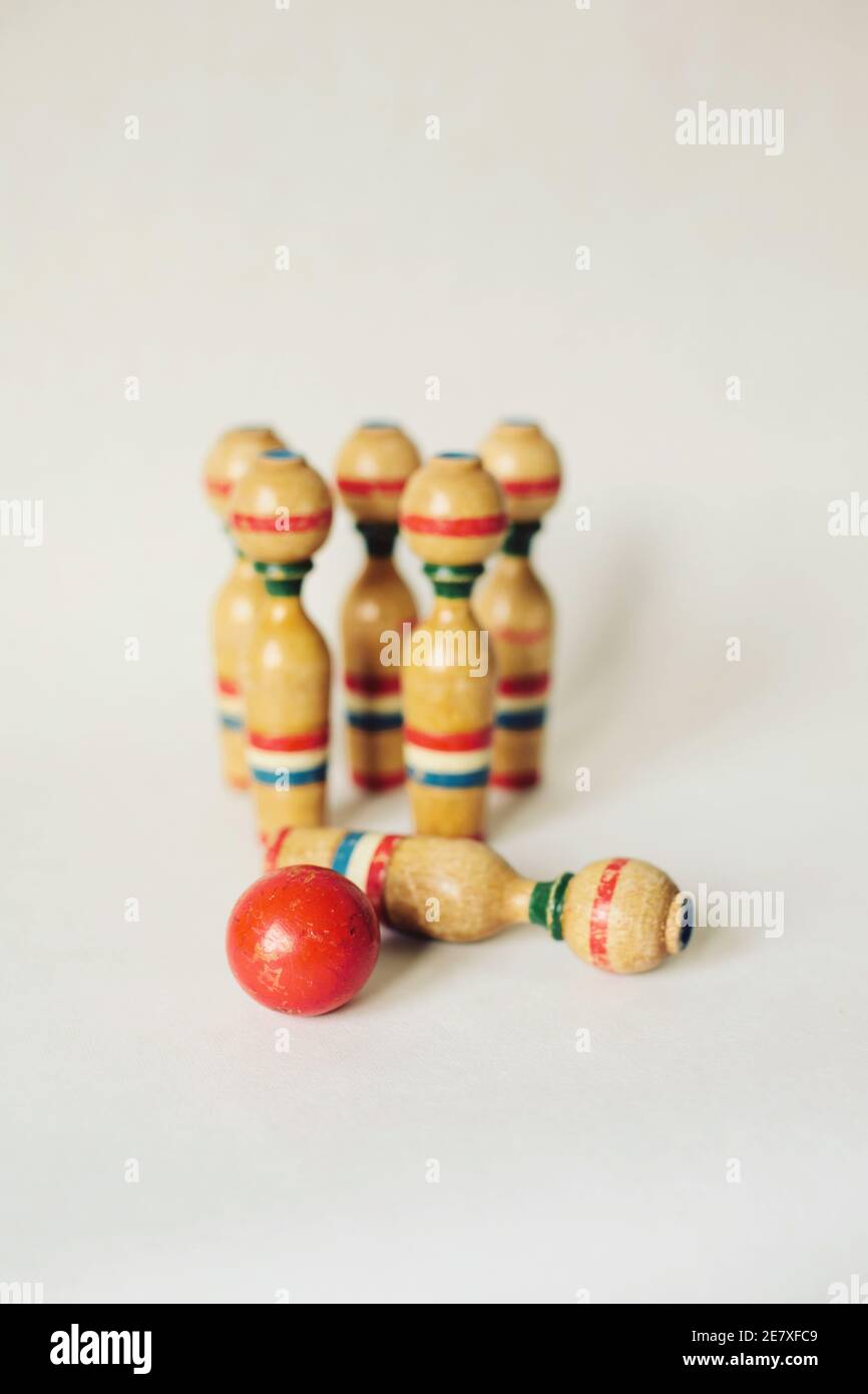 Eine Gruppe von alten hölzernen Bowling Kegeln und rote Kugel Mit einem umgeklopft Stockfoto