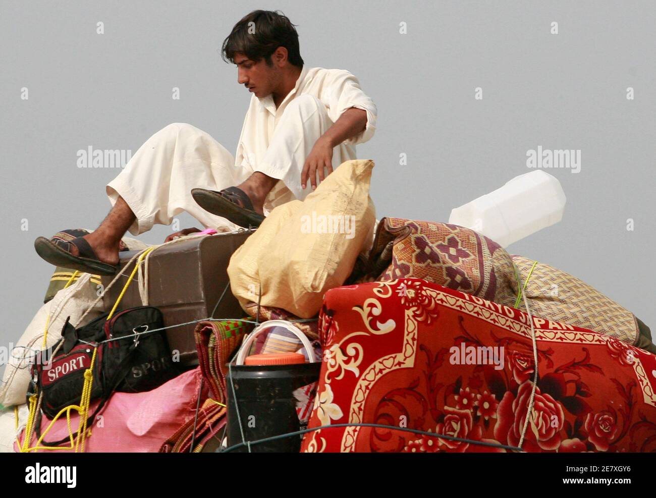 Ein Binnenvertriebener, Der einige Monate zuvor vor einer Militäroffensive gegen die Taliban in der Region Swat Valley geflohen war, saß mit seinen Habseligkeiten auf einem Lastwagen und kehrte auf der Straße durch den Distrikt Malakand, etwa 170 km (106 Meilen) nordwestlich von Pakistans Hauptstadt Islamabad, am 2. August 2009 in sein Haus zurück. REUTERS/Faisal Mahmood (PAKISTAN POLITIK KONFLIKT GESELLSCHAFT) Stockfoto