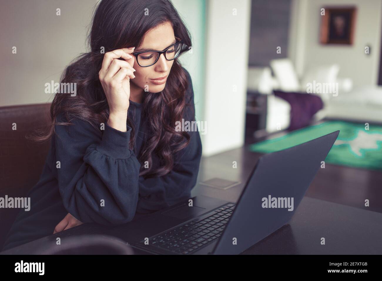 Müde junge intelligente kaukasische Frau im Home Office am Laptop Stockfoto